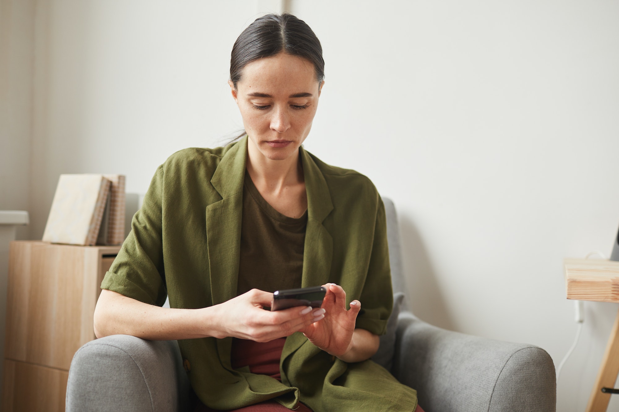 Serious Woman Using Smartphone at Home